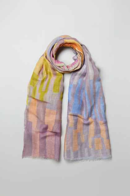 The Soft Stripe Linen Blend Scarf features a lightweight design with geometric patterns in pastel yellow, pink, blue, and purple, showcased on a plain background.