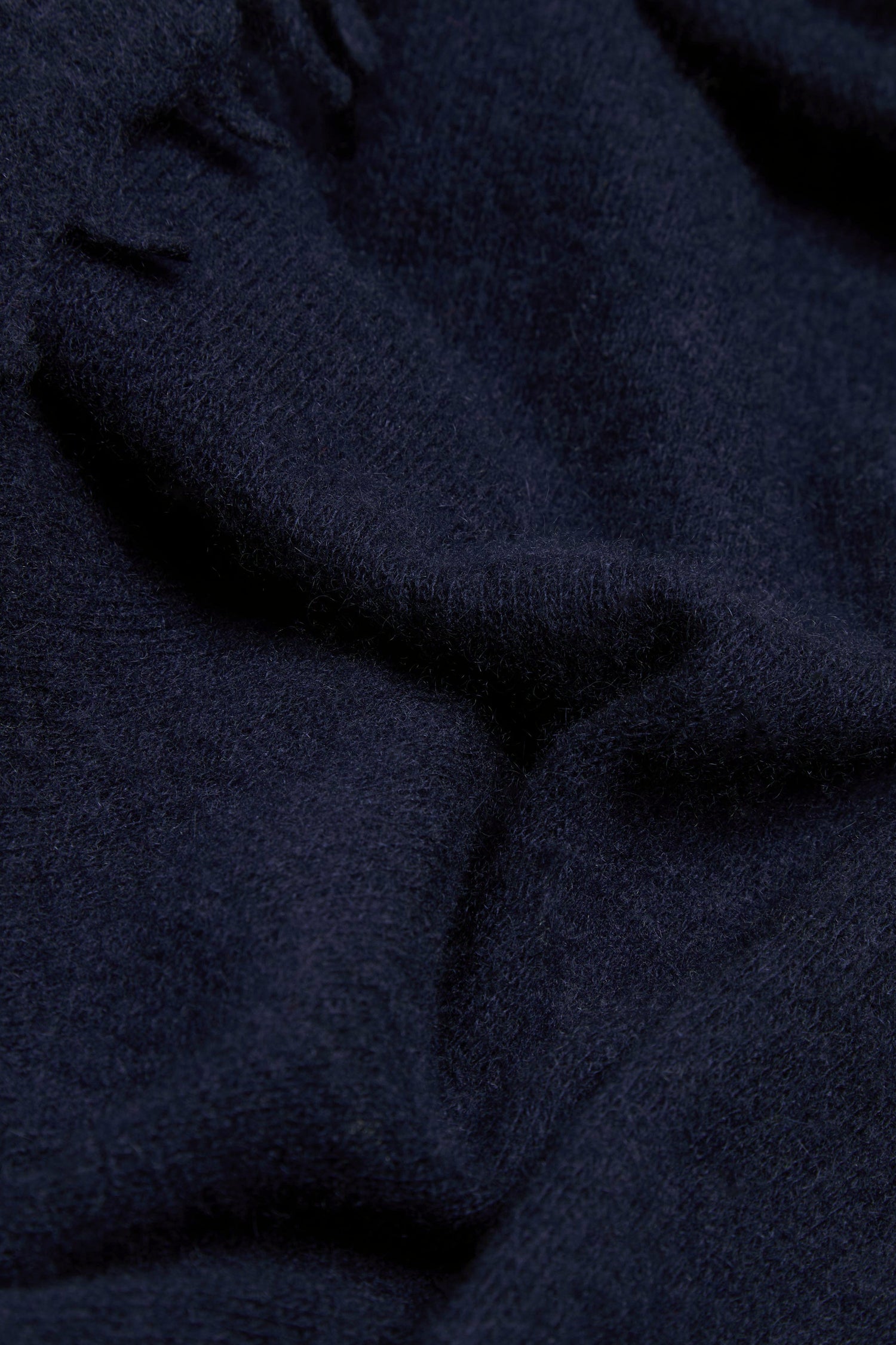 Close-up of the Navy Soft Cashmere Scarf, featuring dark blue wool or fleece fabric with a soft texture and gentle folds.