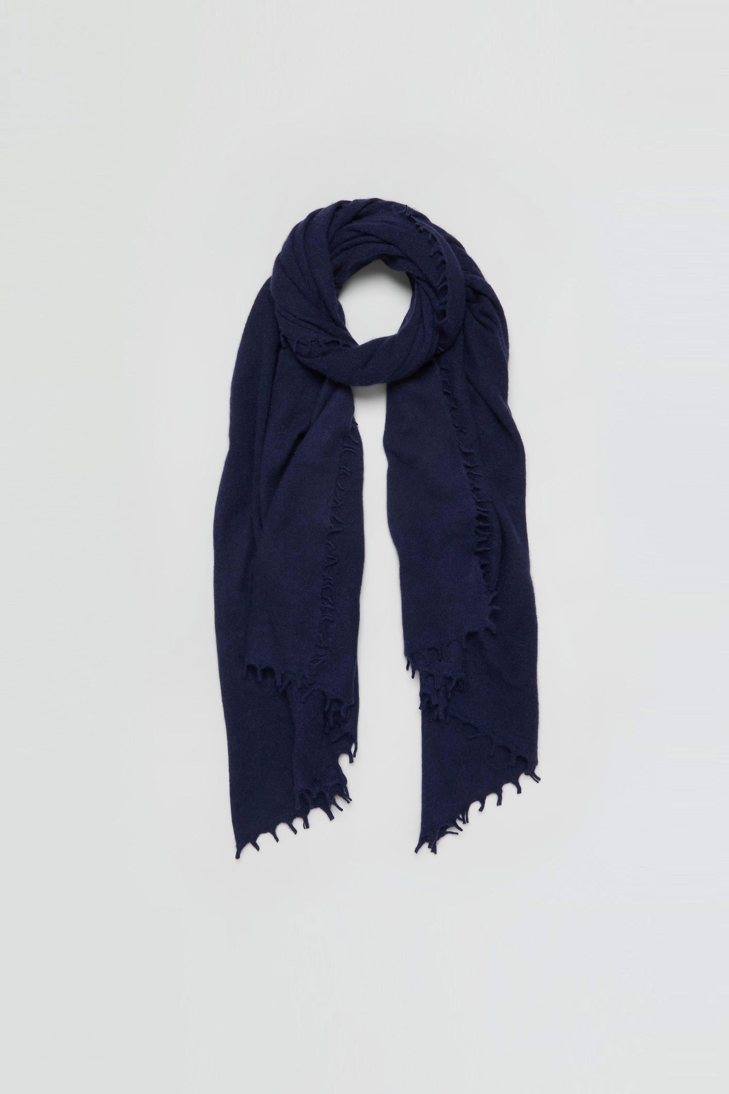 The Navy Soft Cashmere Scarf is shown against a plain light background, featuring frayed edges.
