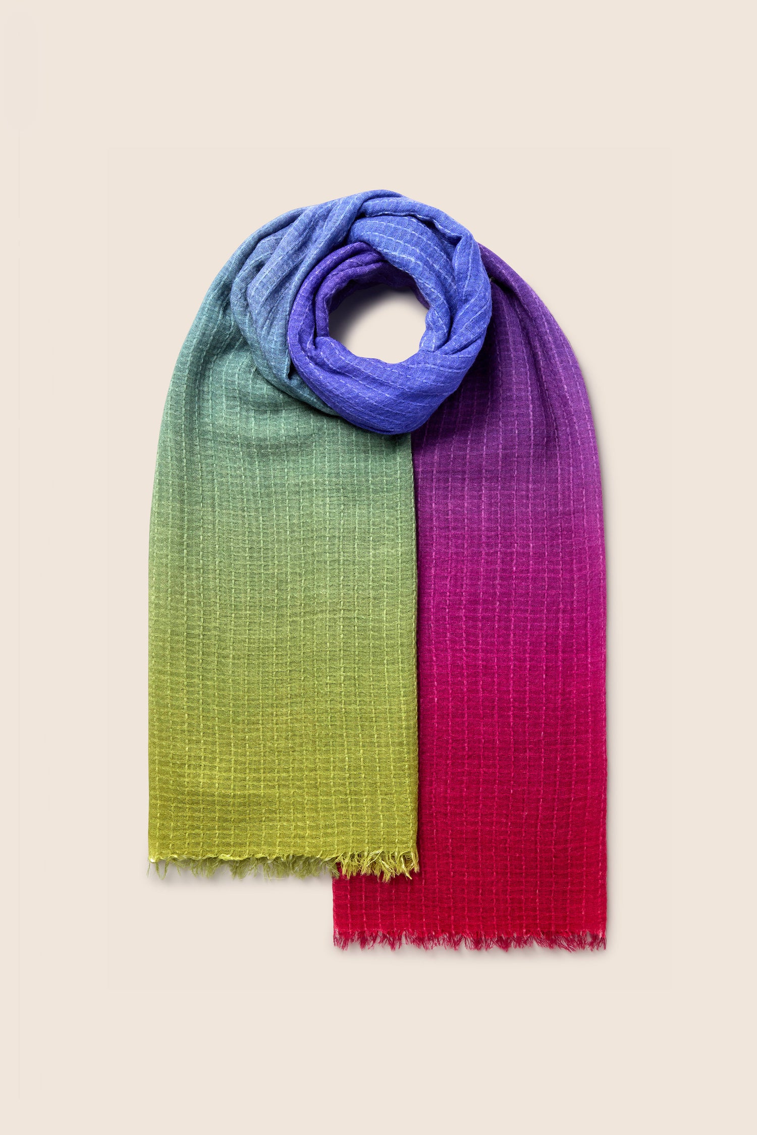 The Soft Colour Blend Wool Scarf showcases a lively gradient that shifts from blue to green, purple, and red against a neutral backdrop. Ideal for any occasion, its rich jewel tones infuse elegance and adaptability into any ensemble.