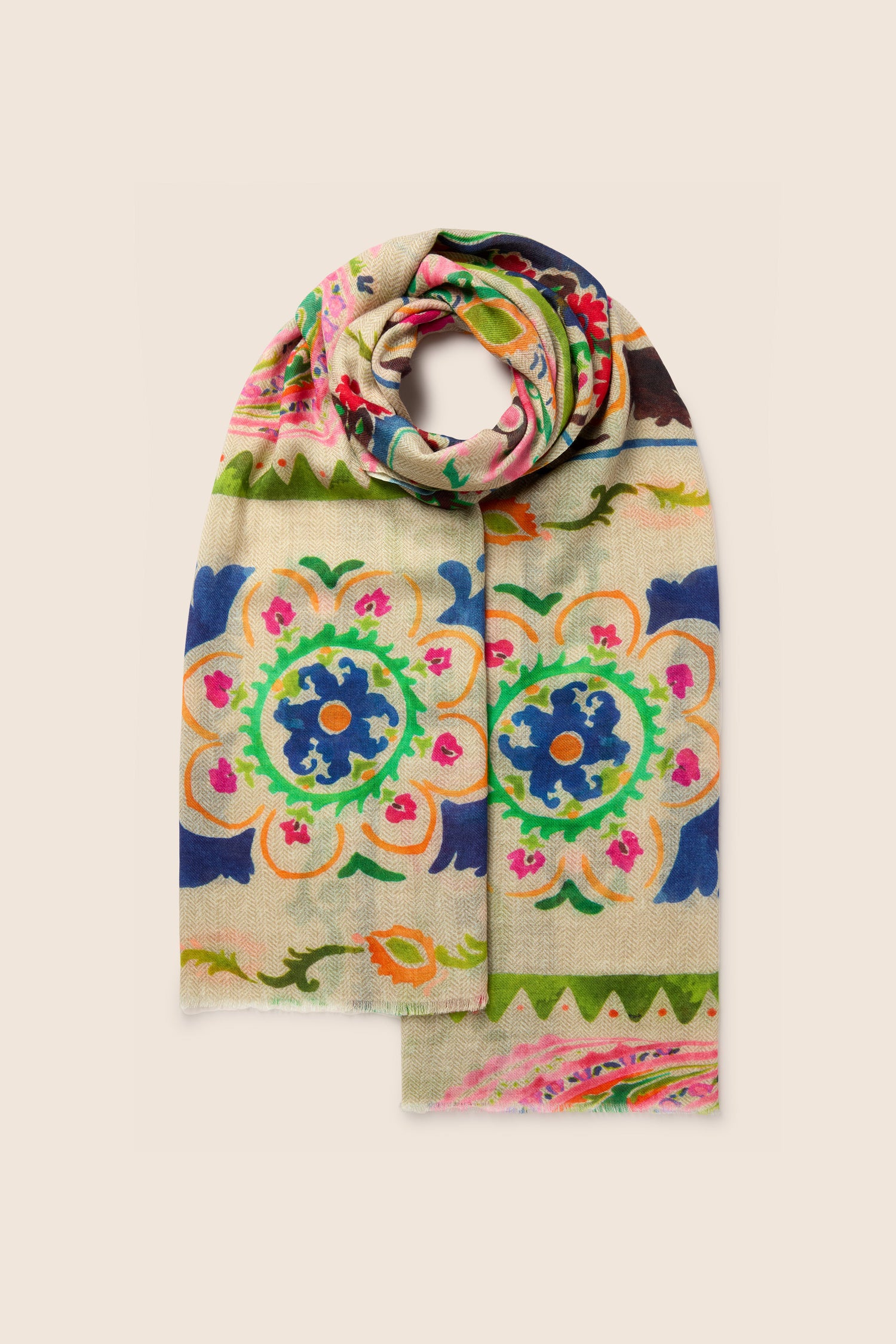 The Painted Paisley Wool Mix Scarf is cream-colored and features a vibrant, intricate floral and geometric pattern in green, pink, blue, and orange. Its hand-painted floral design makes it perfect for all-occasion styling.