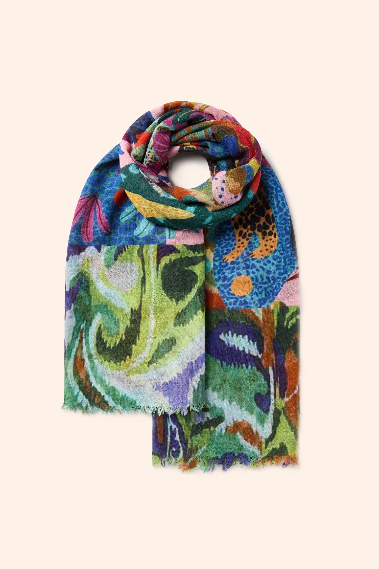 A vibrant Jungle Print Wool Scarf, elegantly rolled up, showcases a multicolor abstract pattern in shades of green, blue, red, yellow, and purple on a beige background. This distinctive accessory is finished with frayed edges.