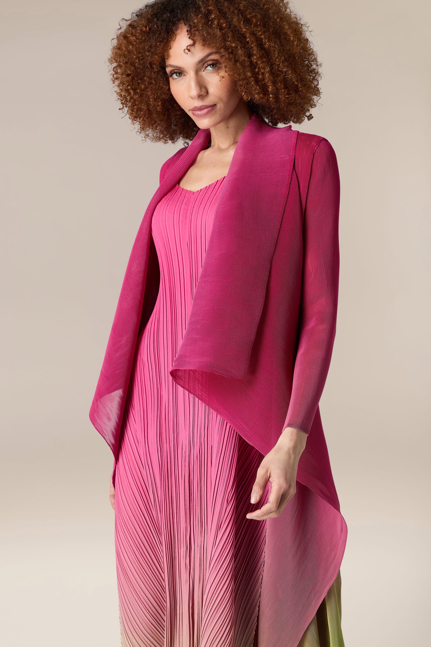 A woman wearing an Alquema Pleated Jacket in pink.