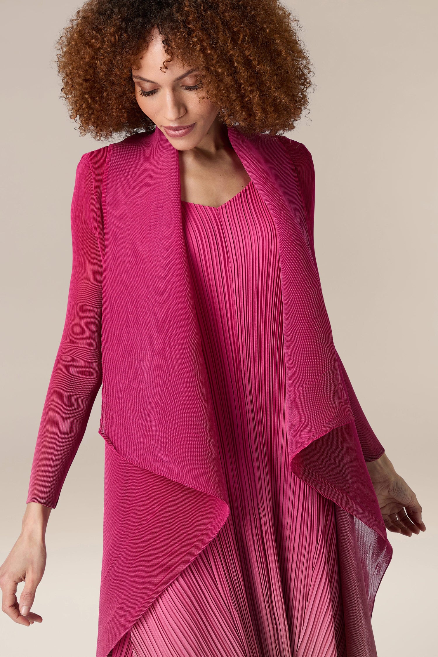 A woman wearing a pink Pleated Jacket.
