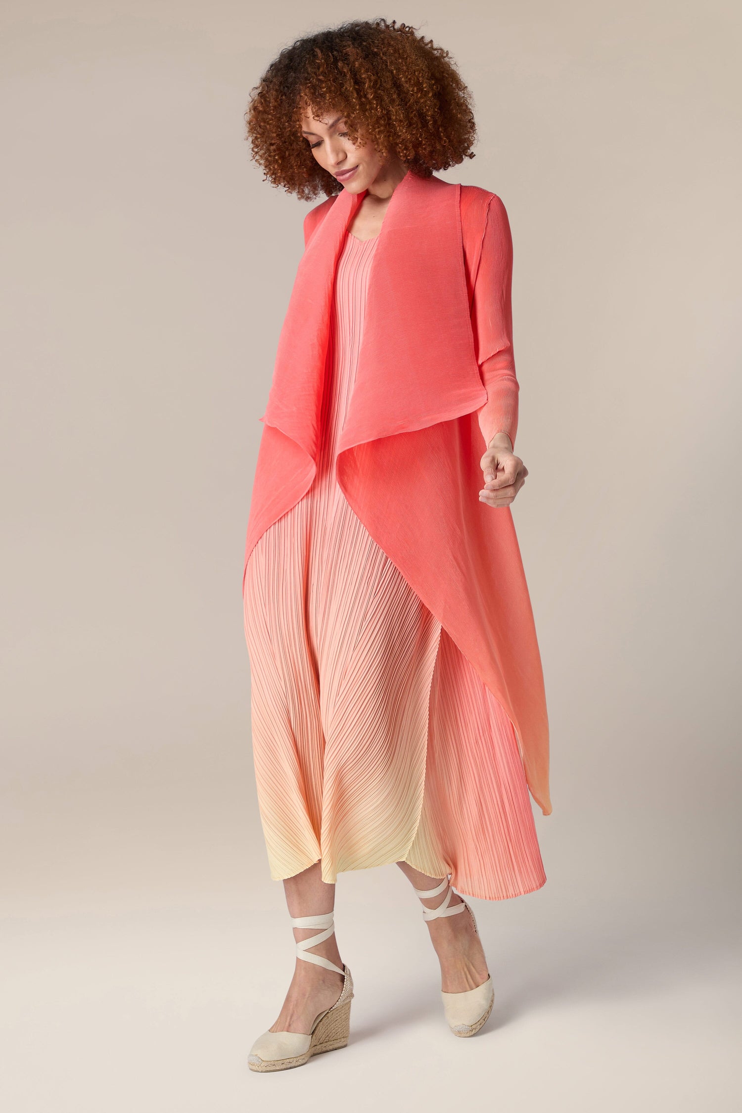 A woman wearing a pink Pleated Jacket.