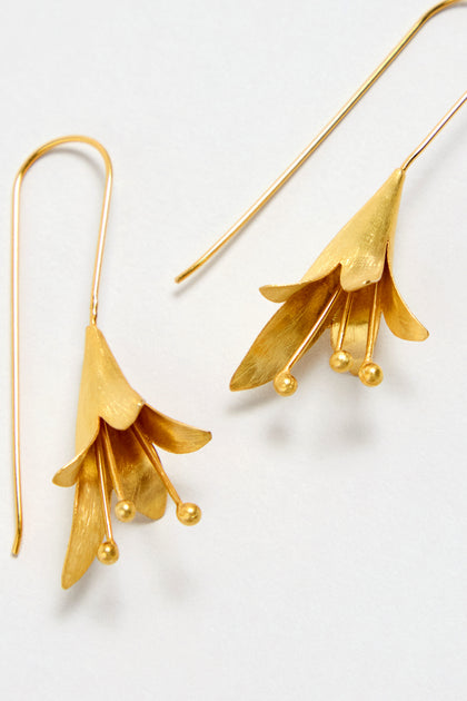 A pair of Gold Vermeil Flower Earrings shaped like stylized blooms, with petal-like layers and small gold ball accents, displayed against a white background.