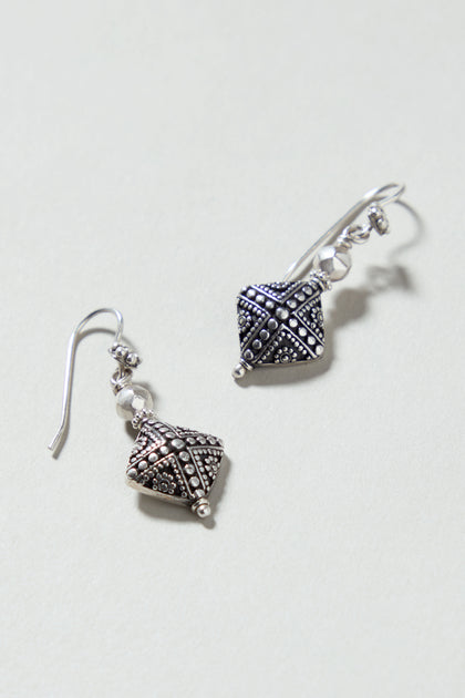Silver Faceted Drop Earrings featuring geometric, textured designs are displayed on a light background.