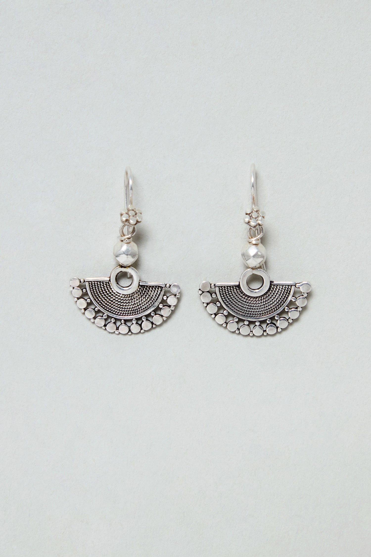 The Silver Mini Fan Earrings are sterling silver earrings featuring semicircular patterned pendants and decorative beads above each pendant, displayed on a light background.