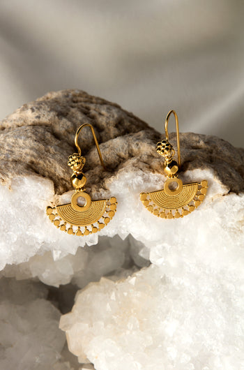 Part of our exclusive Jewellery Collection, the Gold Vermeil Mini Fan Earrings feature stunning gold vermeil semi-circle dangles with an intricate design, beautifully showcased on a crystal-like rock surface.