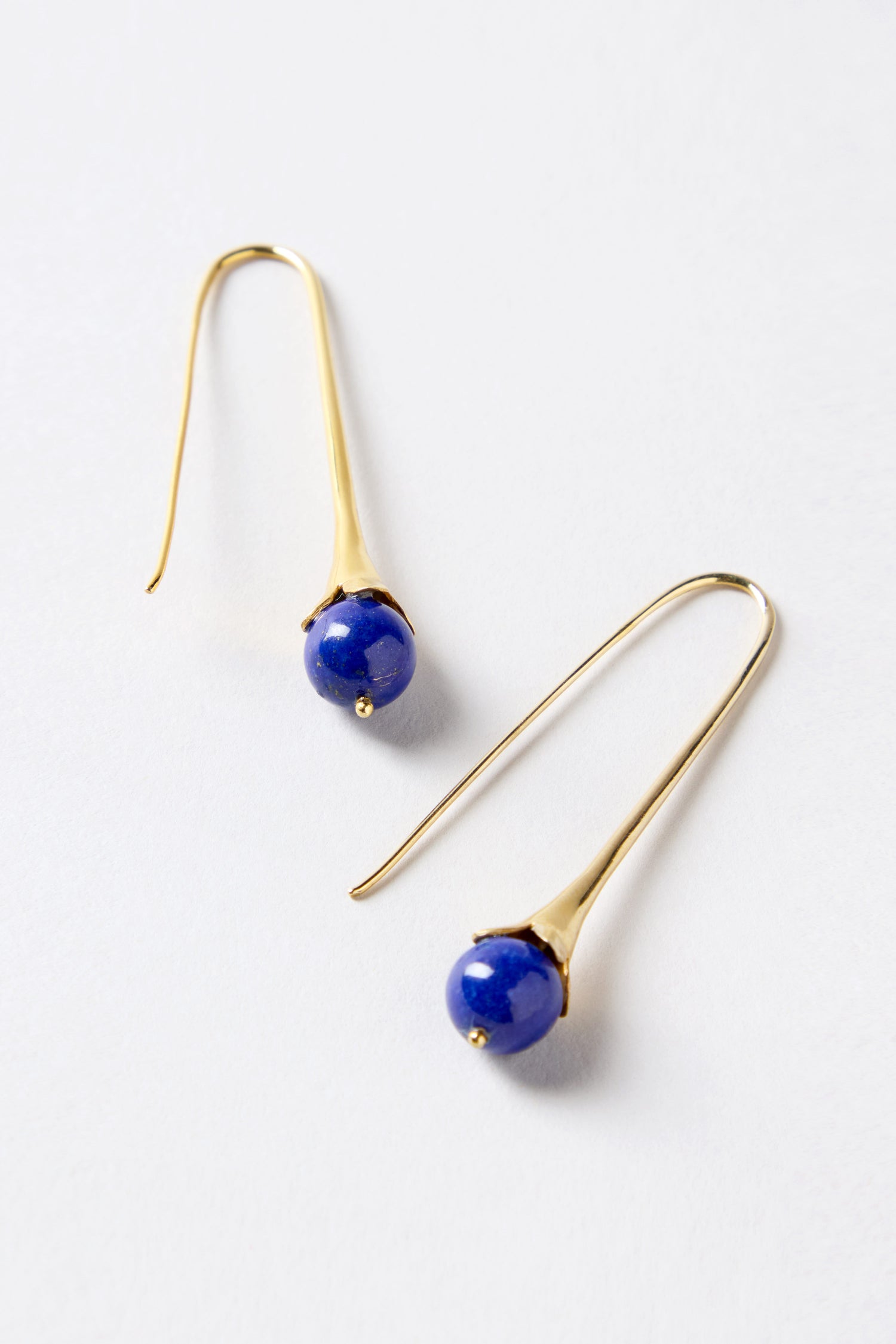 Gold Vermeil Lapis Drop Earrings with long, slender hooks and round blue stone beads at the ends, elegantly displayed on a white surface.