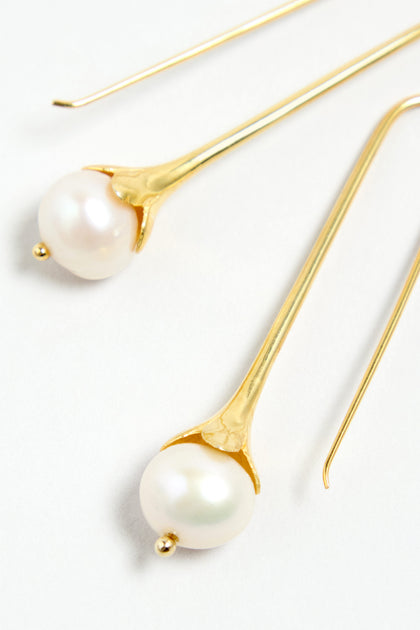 Gold Vermeil Pearl Drop Earrings featuring round white pearls in an elegant elongated drop design, set against a white background.