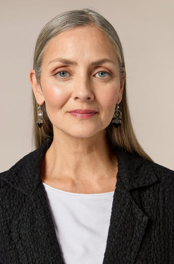 A woman wearing a black jacket and white shirt accessorized with Silver and Black Onyx Tuareg Earrings.