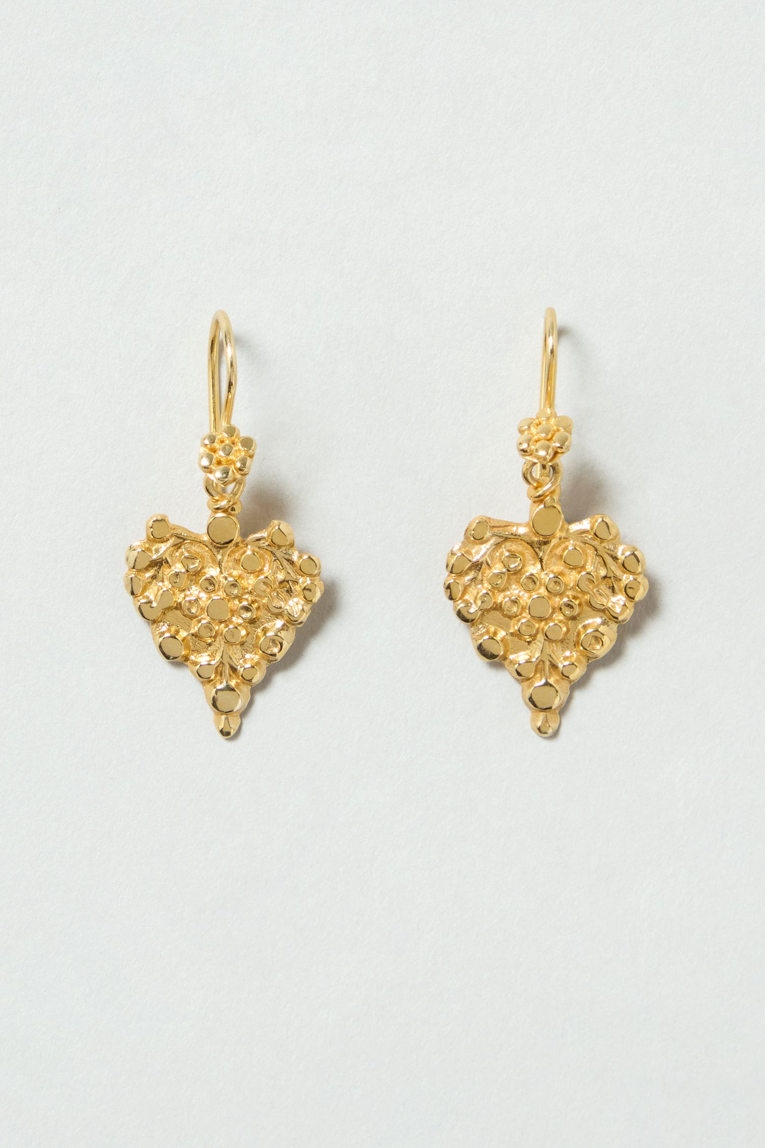Gold Vermeil Heart Earrings featuring textured, floral-inspired detailing and a heart-shaped drop design, shown against a light background.