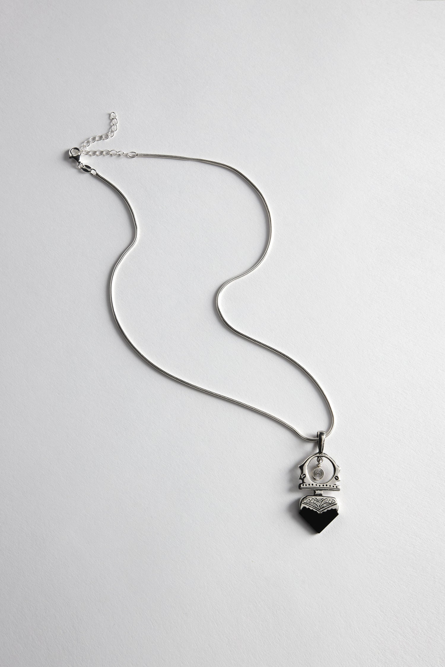 Tuareg Silver and Black Onyx Pendant necklace with a handcrafted design, featuring a heart-shaped black onyx pendant on a plain white surface.