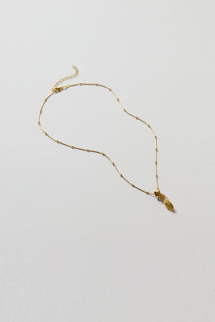 The Gold Vermeil Pearl Drop Necklace, featuring a delicate design with small beads and a pearl drop pendant, is elegantly displayed against a plain white background.