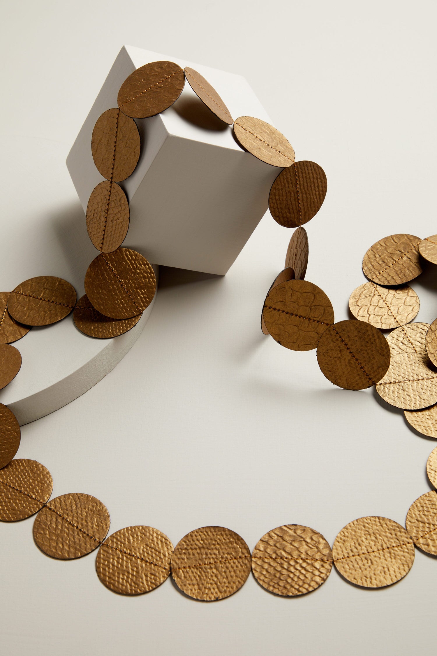 The Dotty Necklace is a stunning piece of jewellery featuring gold circles on top of a white box.