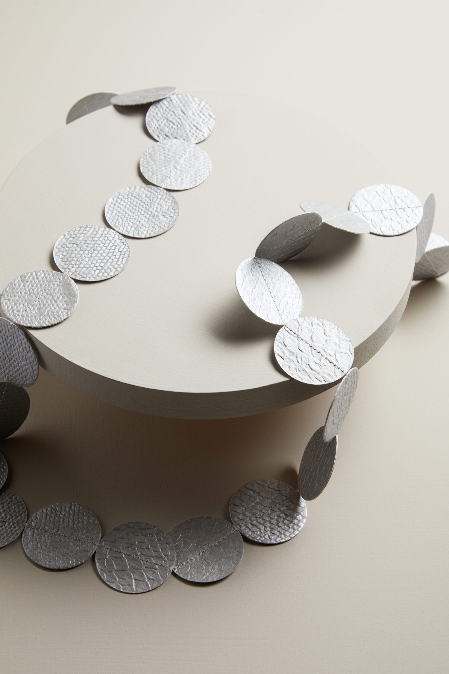 A white plate with silver circles on it became the Dotty Necklace.