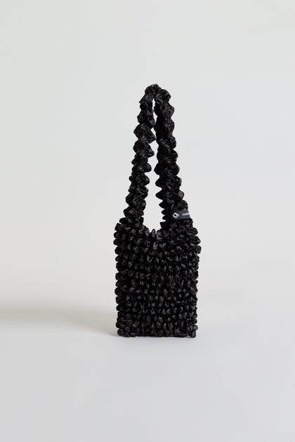 Black Shibori Pleated Bag with a ruched texture and a matching gathered shoulder strap.