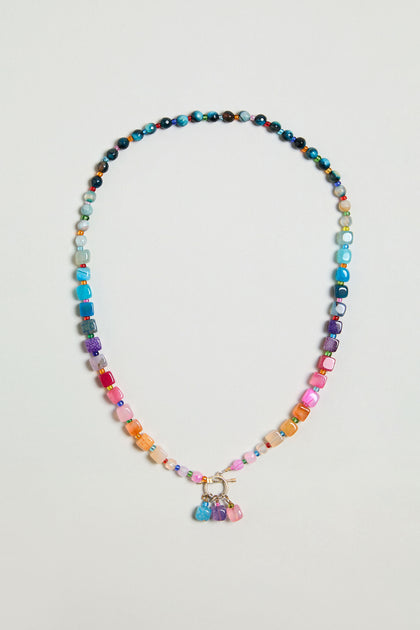 The Artisanal Rainbow Agate Toggle Necklace features multicolored agate beads in assorted shapes and sizes, accented with a cluster of vibrant charms at the center—handmade with care in Scotland.