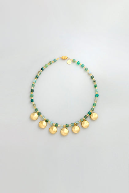 The Faceted Green Agate Charm Necklace features green agate beads, gold and green bead accents, and six round gold pendants evenly spaced for a striking charm necklace look.