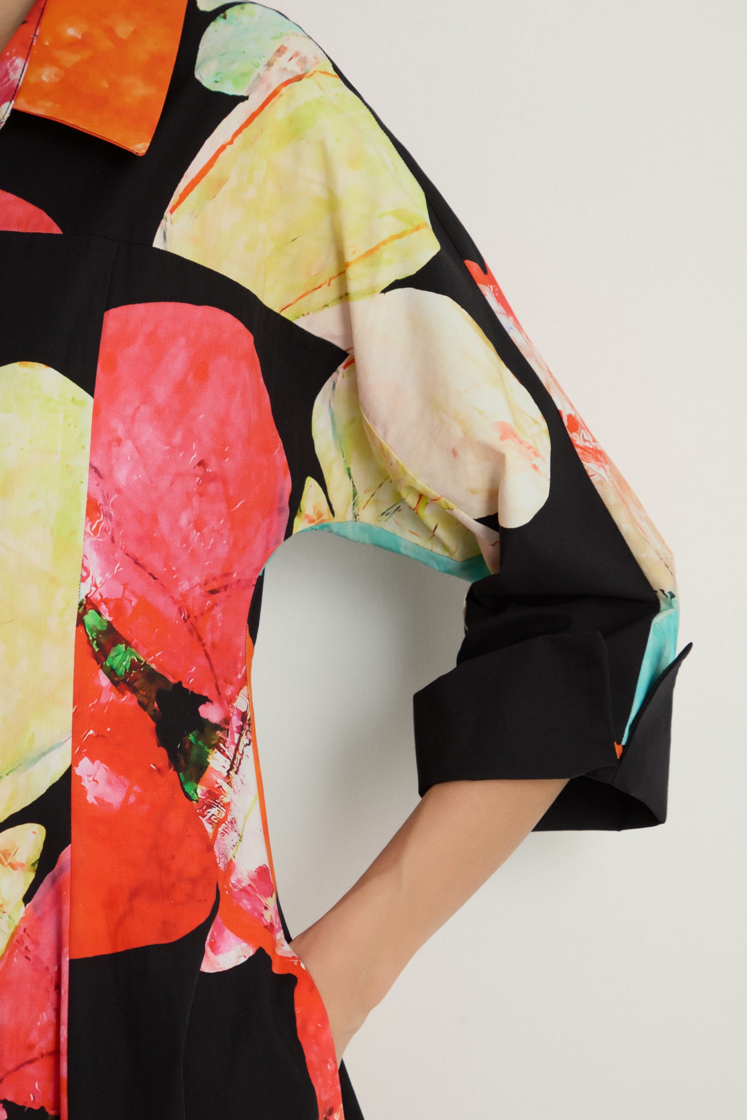 A person in a black shirt with abstract prints stands next to someone wearing the Bright Floral Flared Dress.