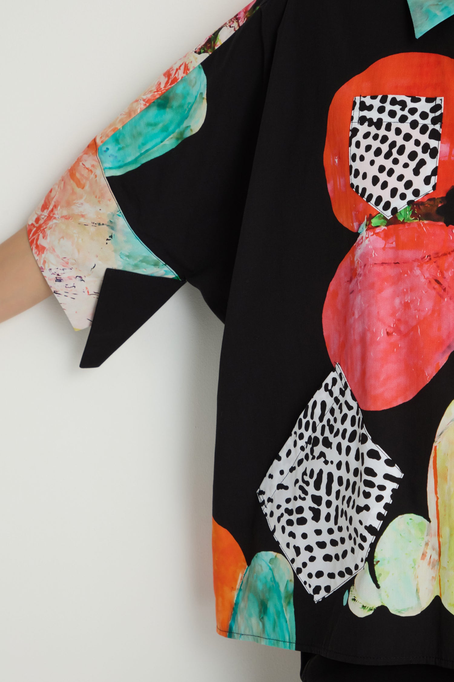 Someone wears the Bright Floral Boxy Shirt, a loose-fitting pure cotton top decorated with colorful abstract shapes and black-and-white dotted patterns.