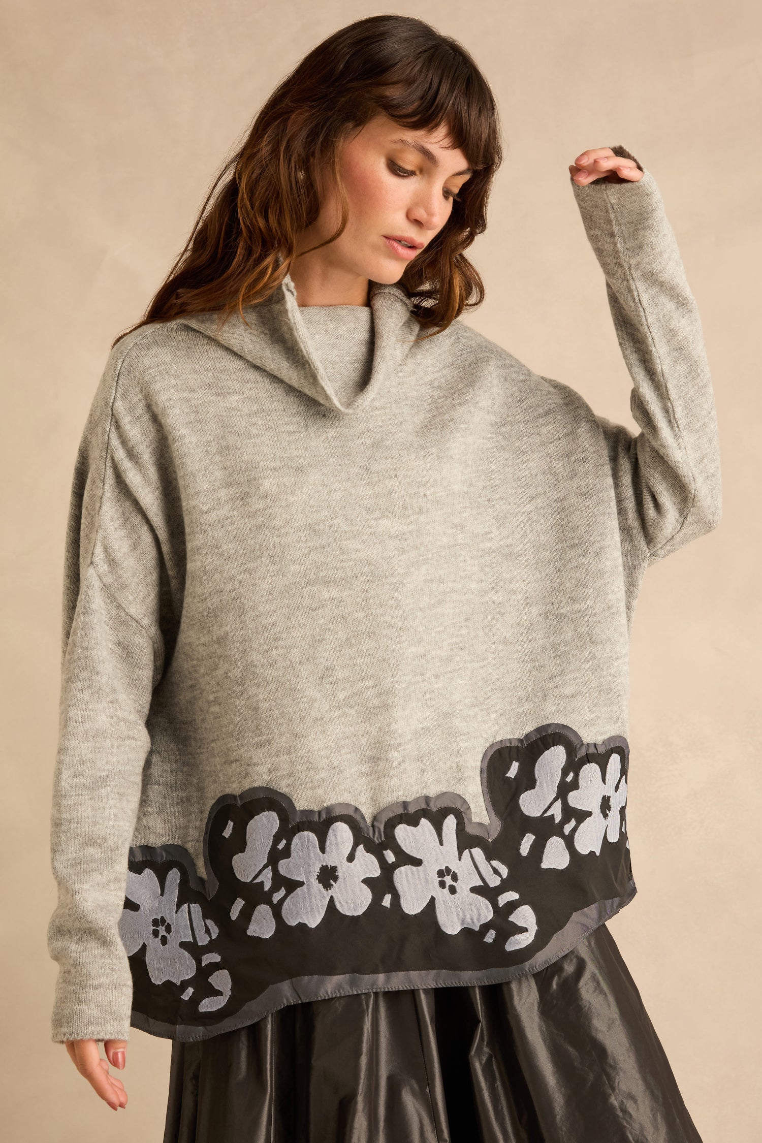 A grey Flower Hem Knit sweater with a cowl neck and a dark hem featuring a white floral pattern.