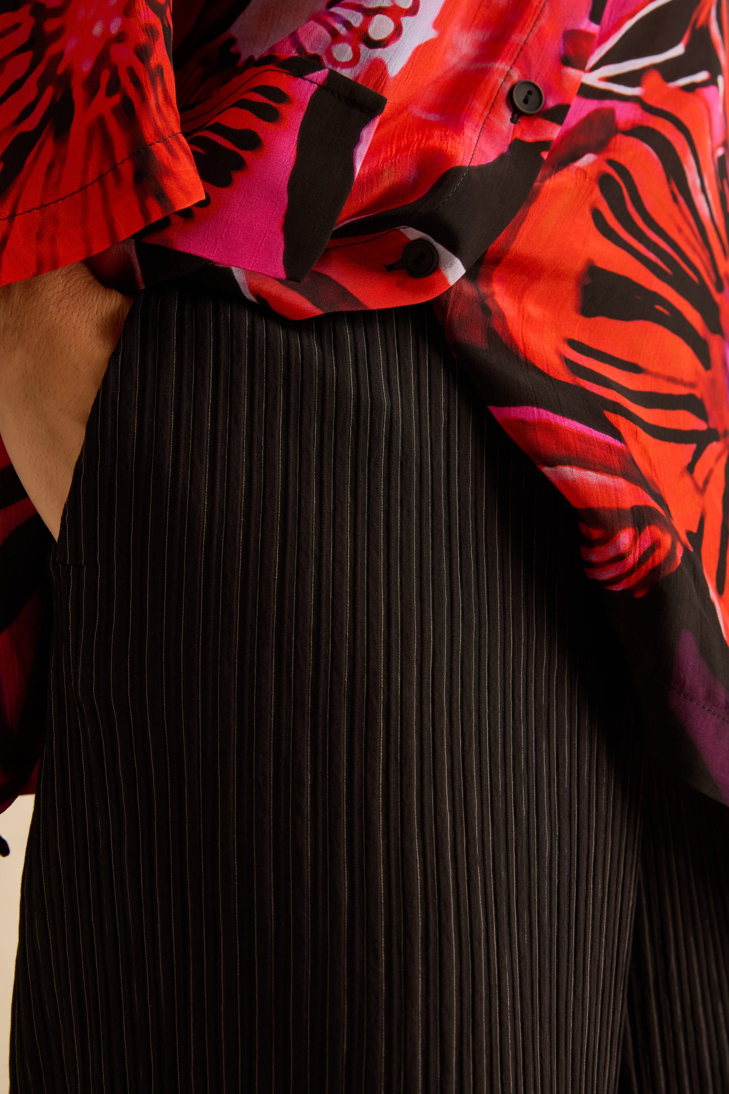 Pin Stripe Wide Leg Trousers in black pinstripe worn with a red and black abstract print shirt.