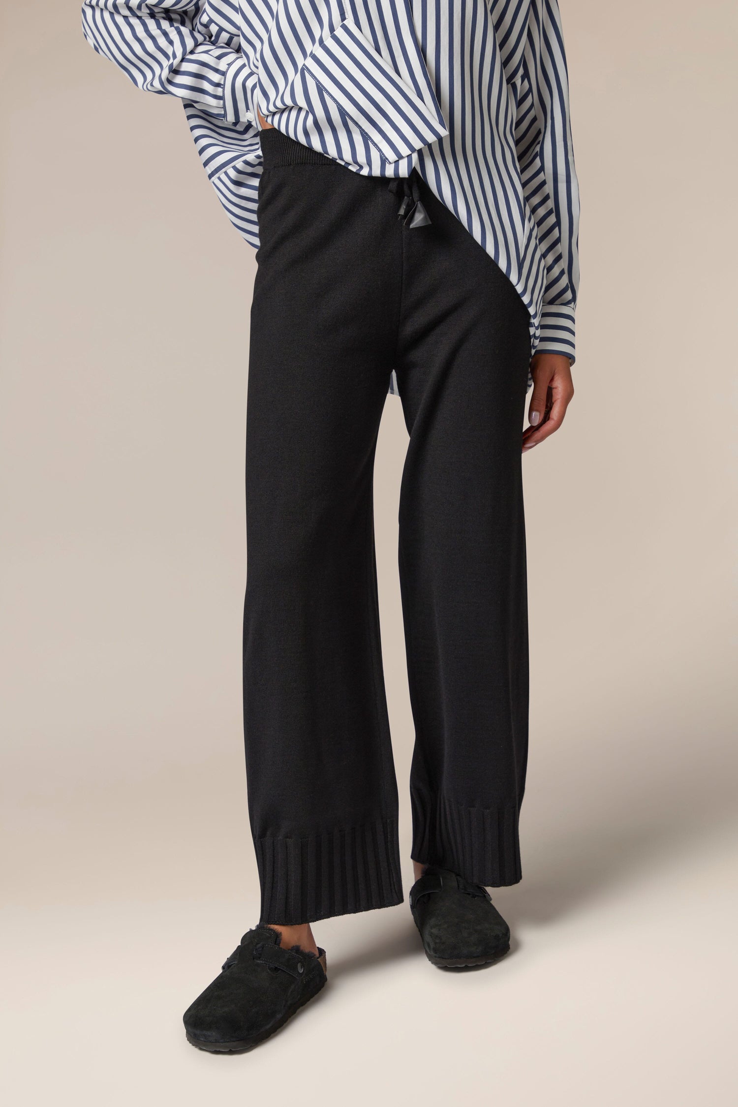 A woman wearing a striped shirt and Rib Hem Knitted Trouser purchased from a Turkish brand.