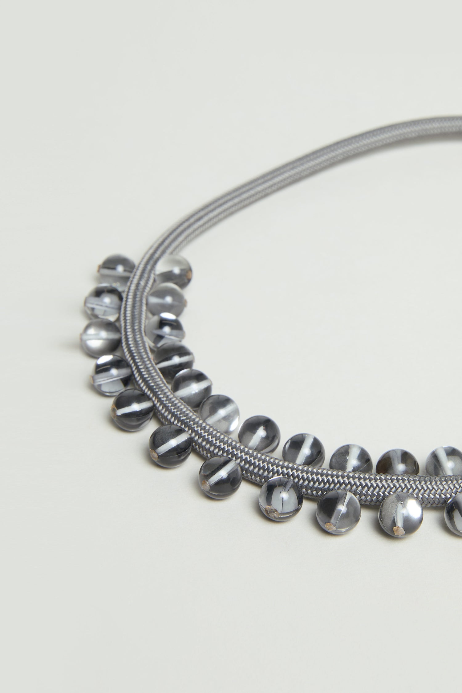 The Smoke Atmosphere Necklace showcases two silver chains and a row of reflective, rounded metallic beads along the lower edge—a stylish, lightweight accessory for jewellery lovers.