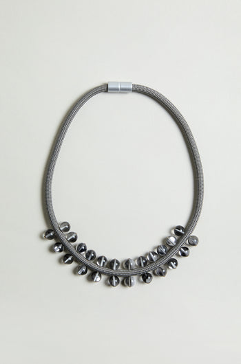 The Smoke Atmosphere Necklace features a metallic textured chain with shiny oval metal beads along the lower half. Lightweight and modern, it's ideal for everyday wear. Shown on a plain light background.