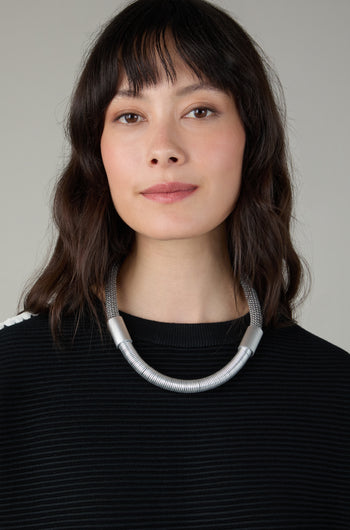 A woman wears the Flow Cord Necklace, highlighting the bold elegance of contemporary jewellery.