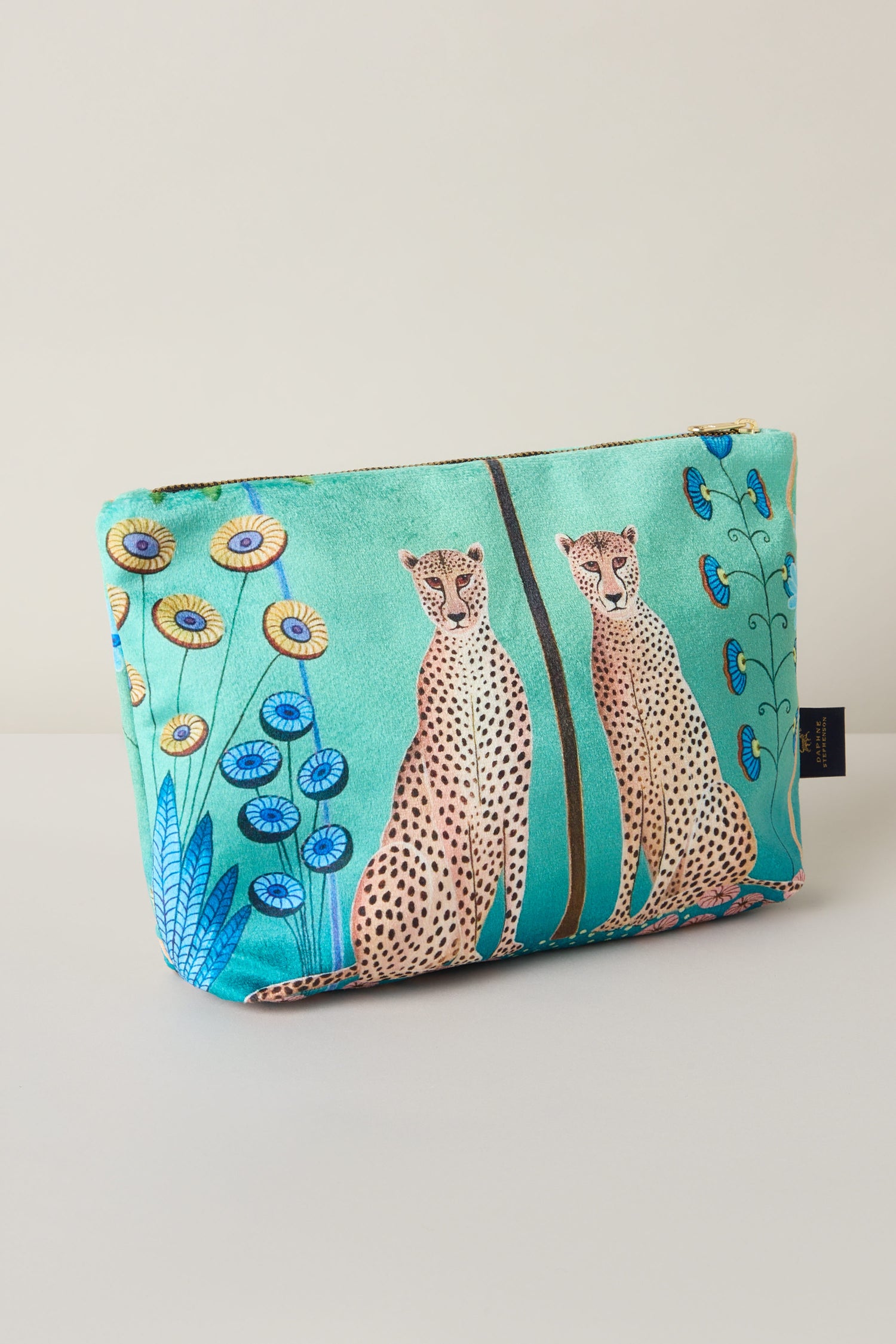 The Large Sunshine Through My Window Velvet Bag features a vibrant design with two cheetahs surrounded by blue flowers set against a turquoise backdrop.