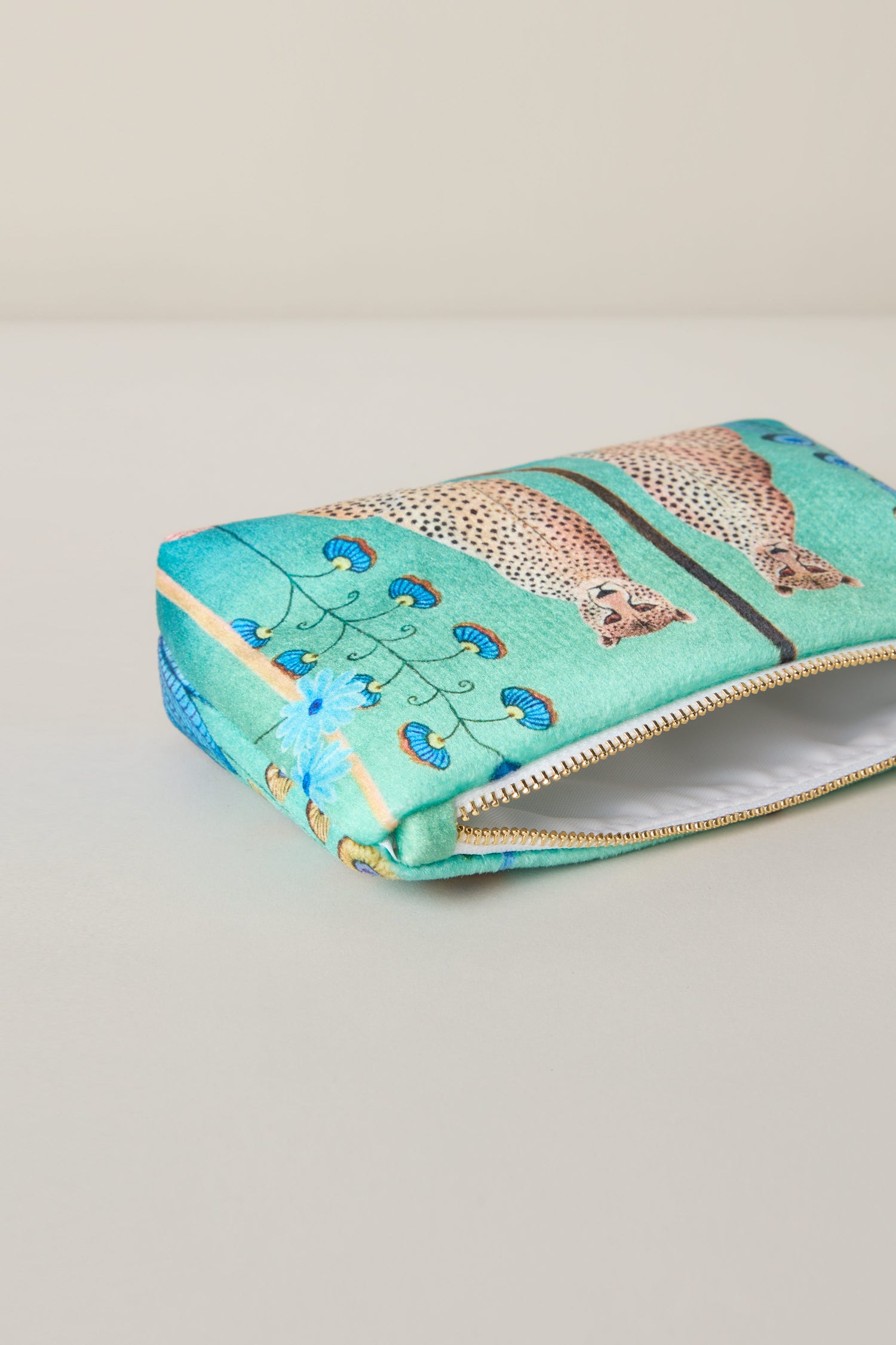 The Small Sunshine Through My Window Velvet Bag is a rectangular zippered pouch adorned with cheetahs intertwined with floral patterns on a light green background.