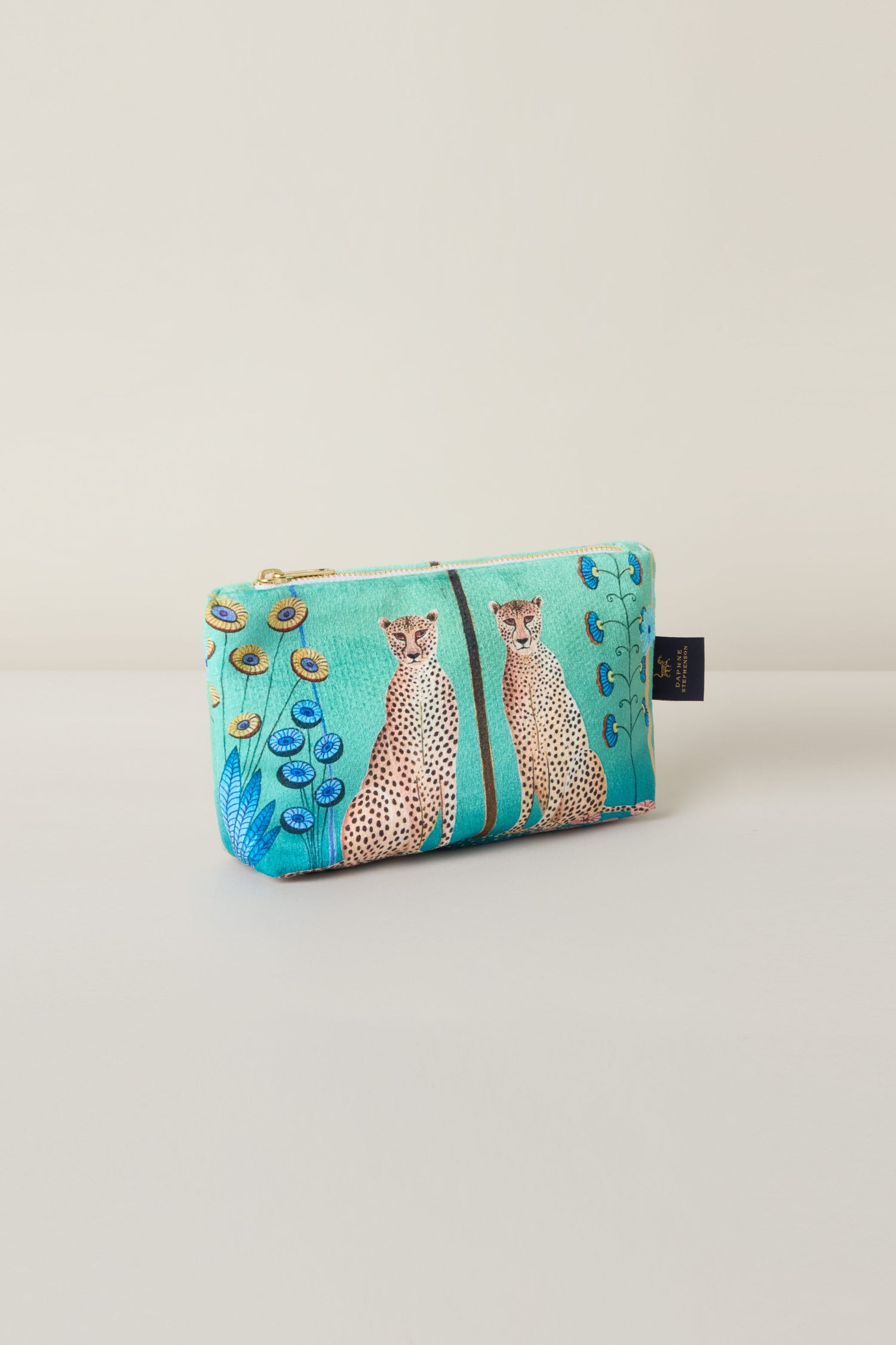 The Small Sunshine Through My Window Velvet Bag, in teal velvet with two cheetahs and floral patterns, rests against a neutral backdrop, evoking serene vibes.