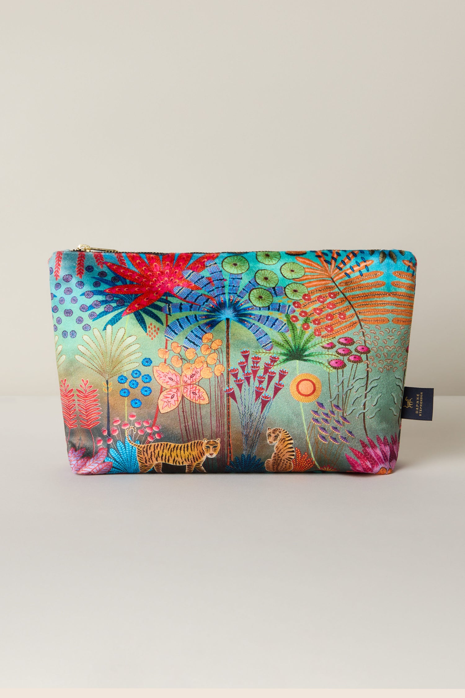 The Large Tale of Two Tigers Velvet Bag showcases a vibrant jungle scene with trees, flowers, and wildlife, including two tigers, inspired by Daphne Stephenson's artwork.