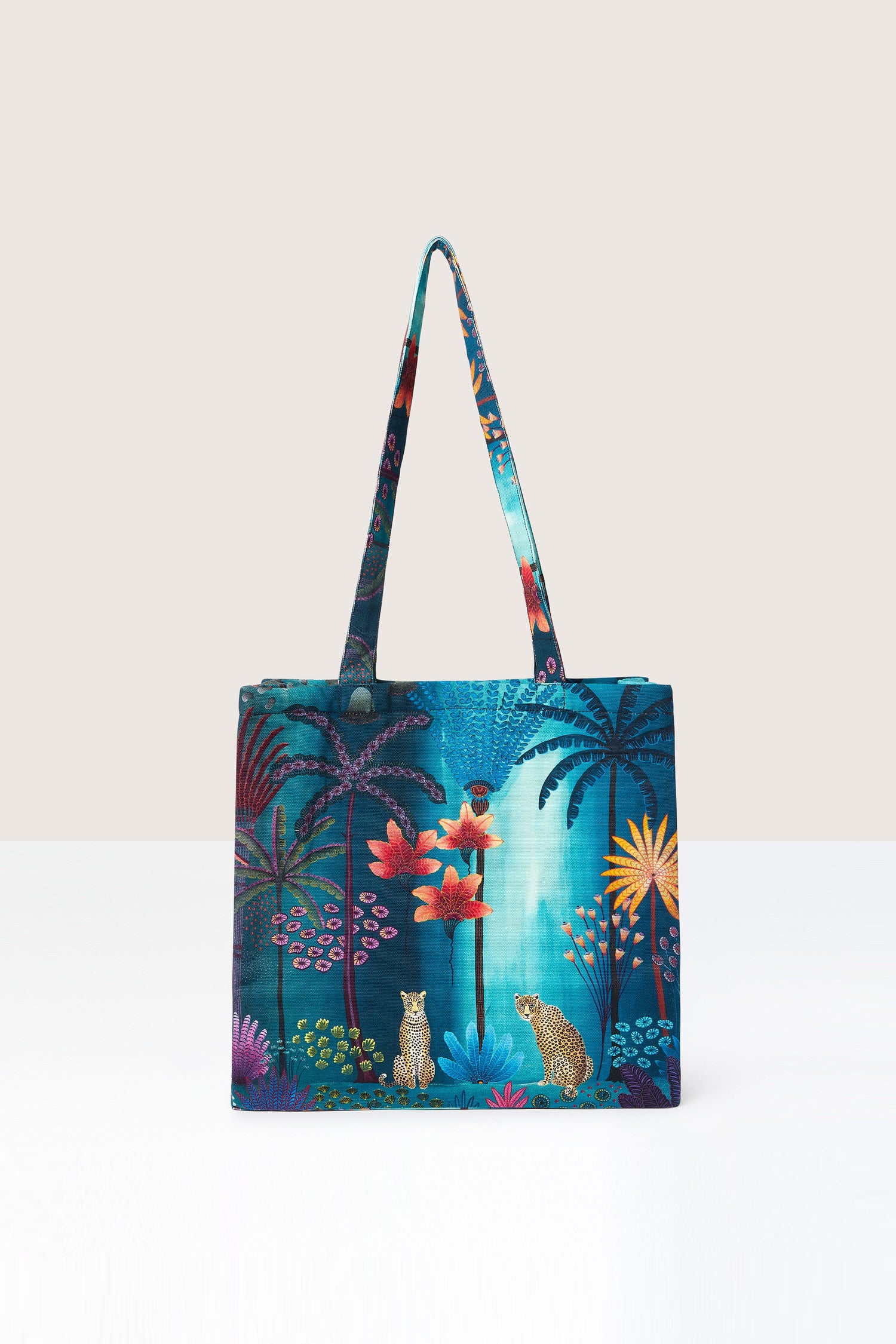 A Twilight Jungle Tote Bag featuring a jungle print, depicting a vibrant tropical scene.