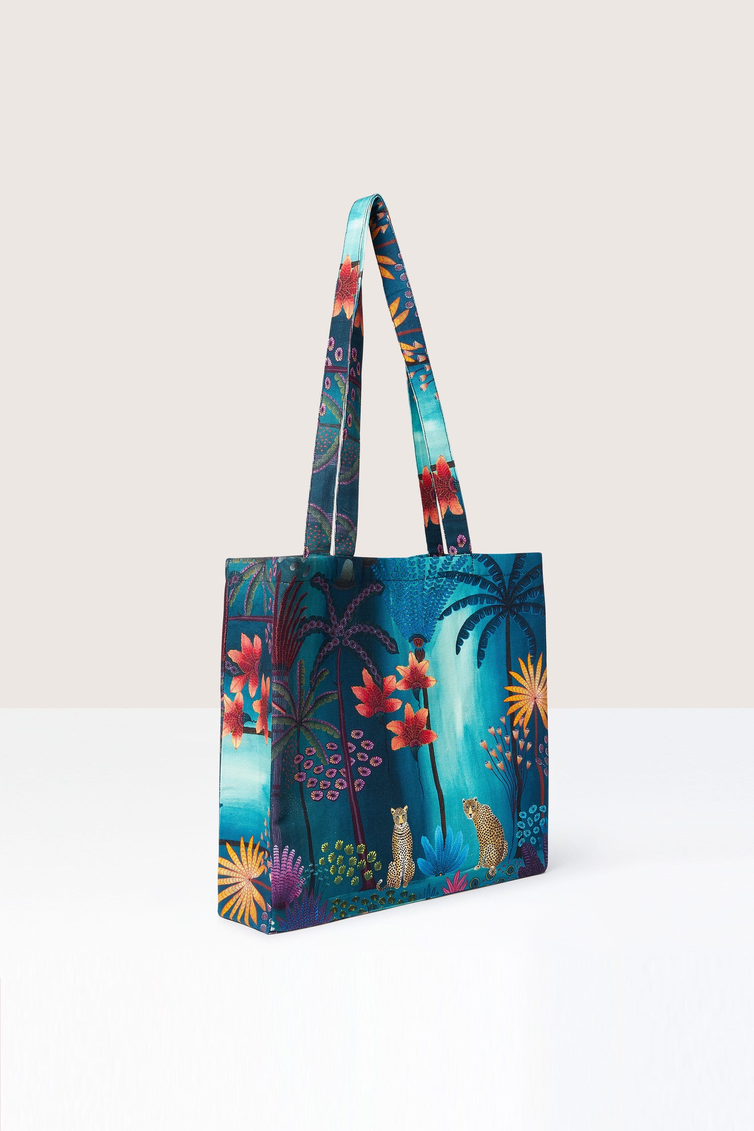 A Twilight Jungle Tote Bag with a tropical print featuring jungle scenes.