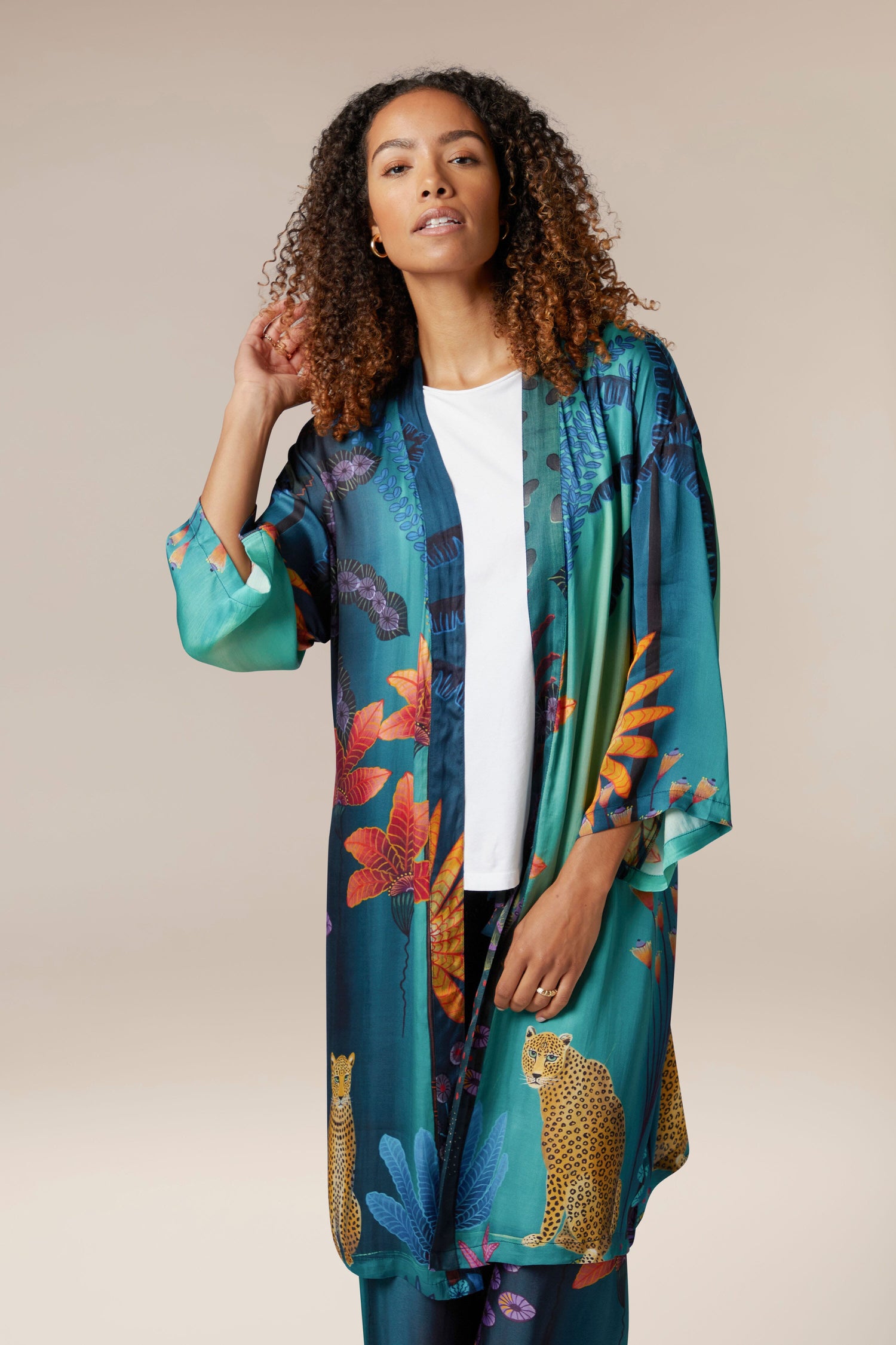 A woman wearing the Twilight Jungle Gown, an exotic teal kimono.