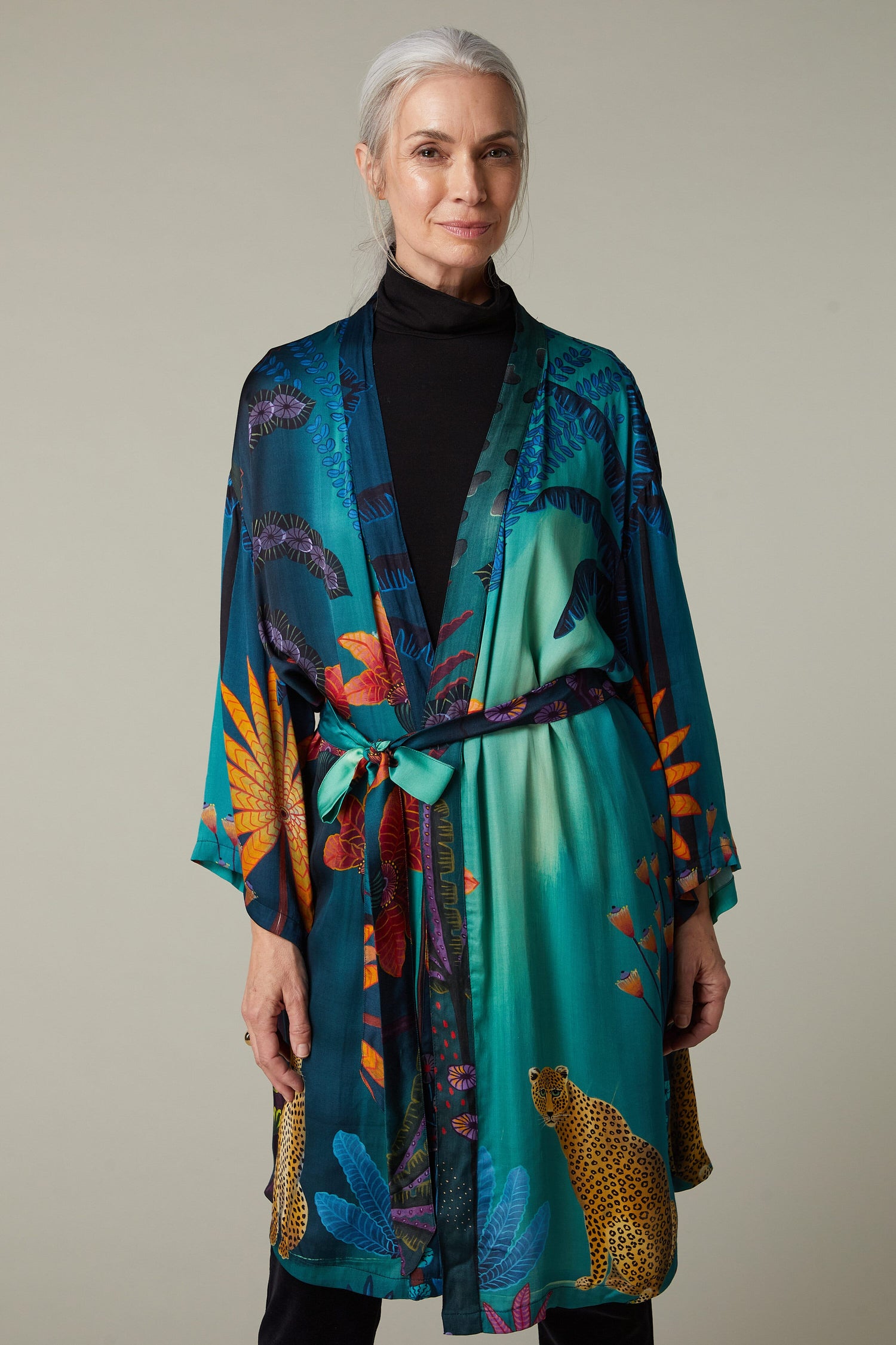 A woman wearing a Twilight Jungle Gown kimono with an exotic tropical print.