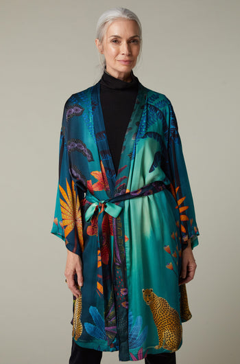 A woman wearing a Twilight Jungle Gown kimono with an exotic tropical print.