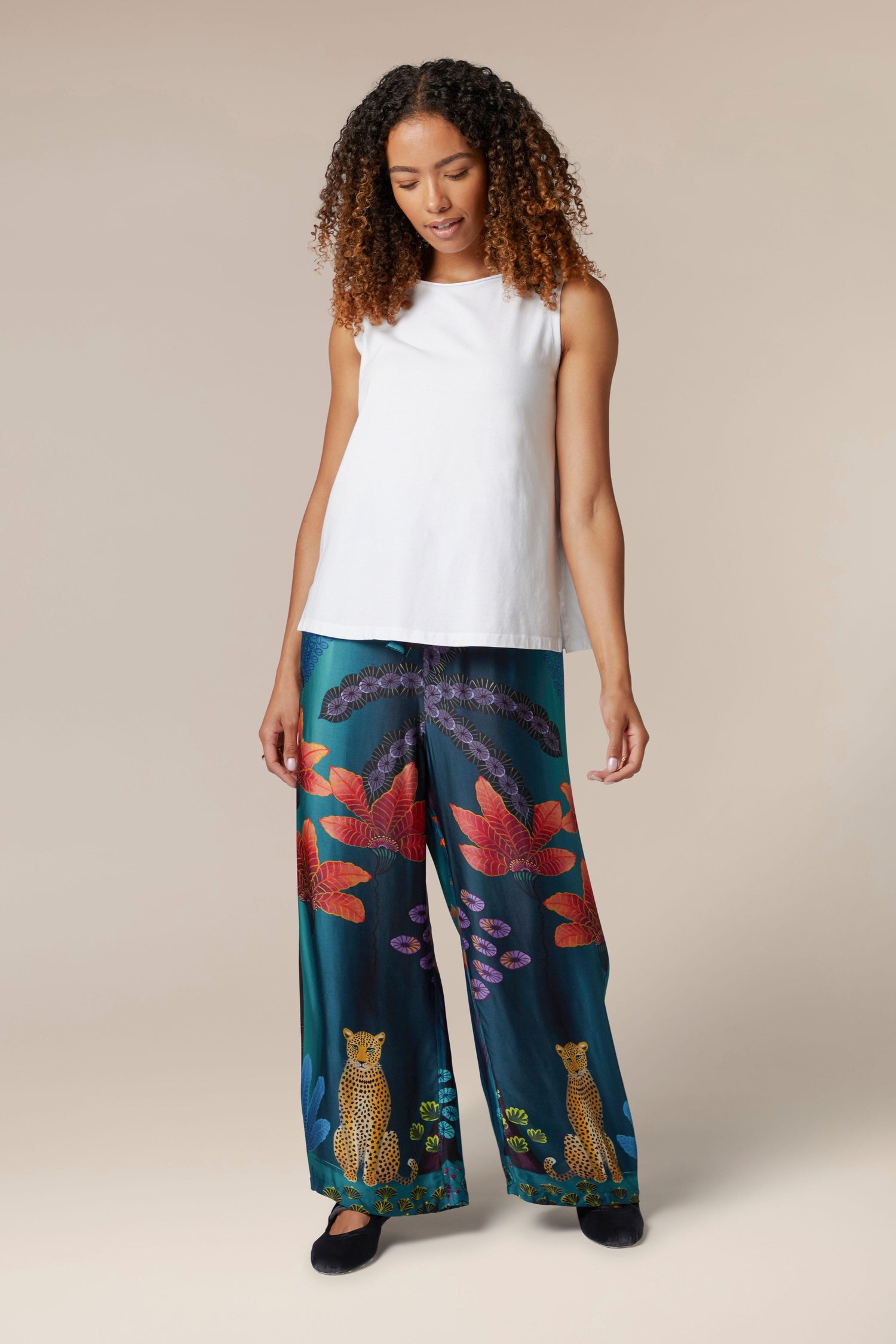 A woman dressed in a top and Twilight Jungle Trousers with a floral print showcasing an exotic style.