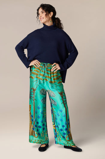 A woman wearing a blue turtleneck and Leopard in Moonlight Trousers in an exotic style.