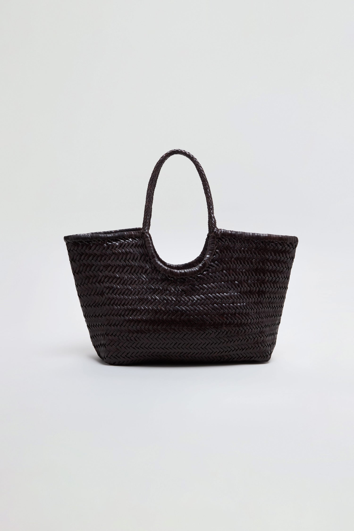 A Nantucket Woven Dark Brown Leather Bag with two handles is displayed against a plain light background, highlighting the refined craftsmanship reminiscent of Dragon Diffusion’s signature handwoven totes.