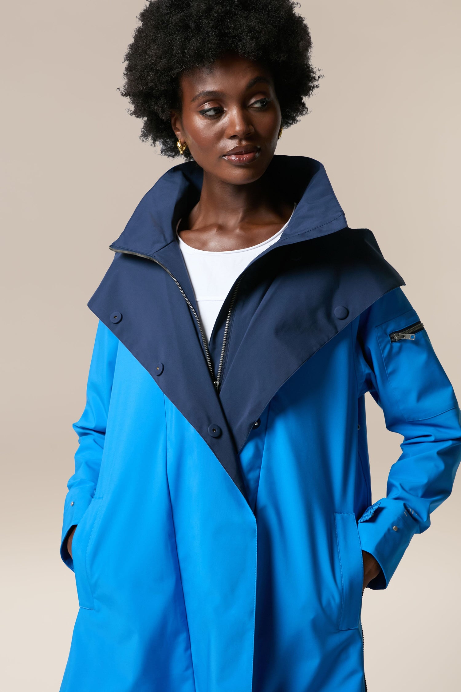 A woman wearing the Denise Wide Collar Rain Jacket from Scandi brand Regn.