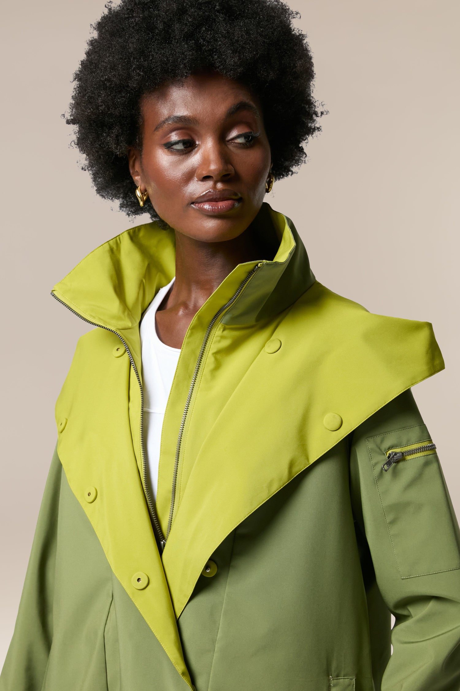 A sustainability-accredited black woman wearing a Denise Wide Collar Rain Jacket made of technical fabrics.