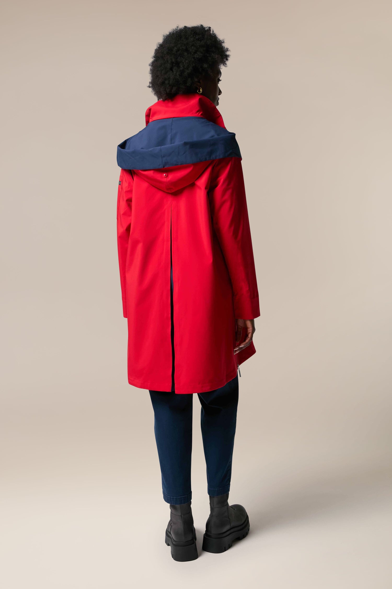 The back view of a woman wearing a sustainability-accredited Denise Wide Collar Rain Jacket from Scandi brand Regn.