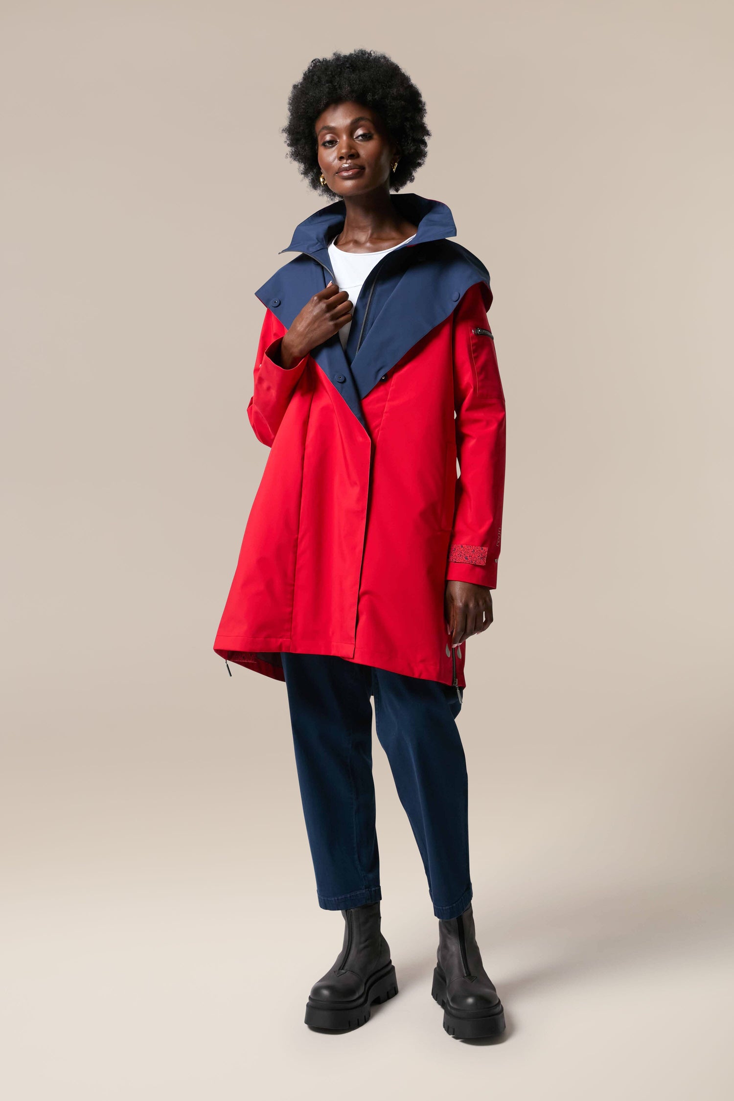 A woman wearing storm-proof rainwear, the Denise Wide Collar Rain Jacket, from Scandi brand Regn.