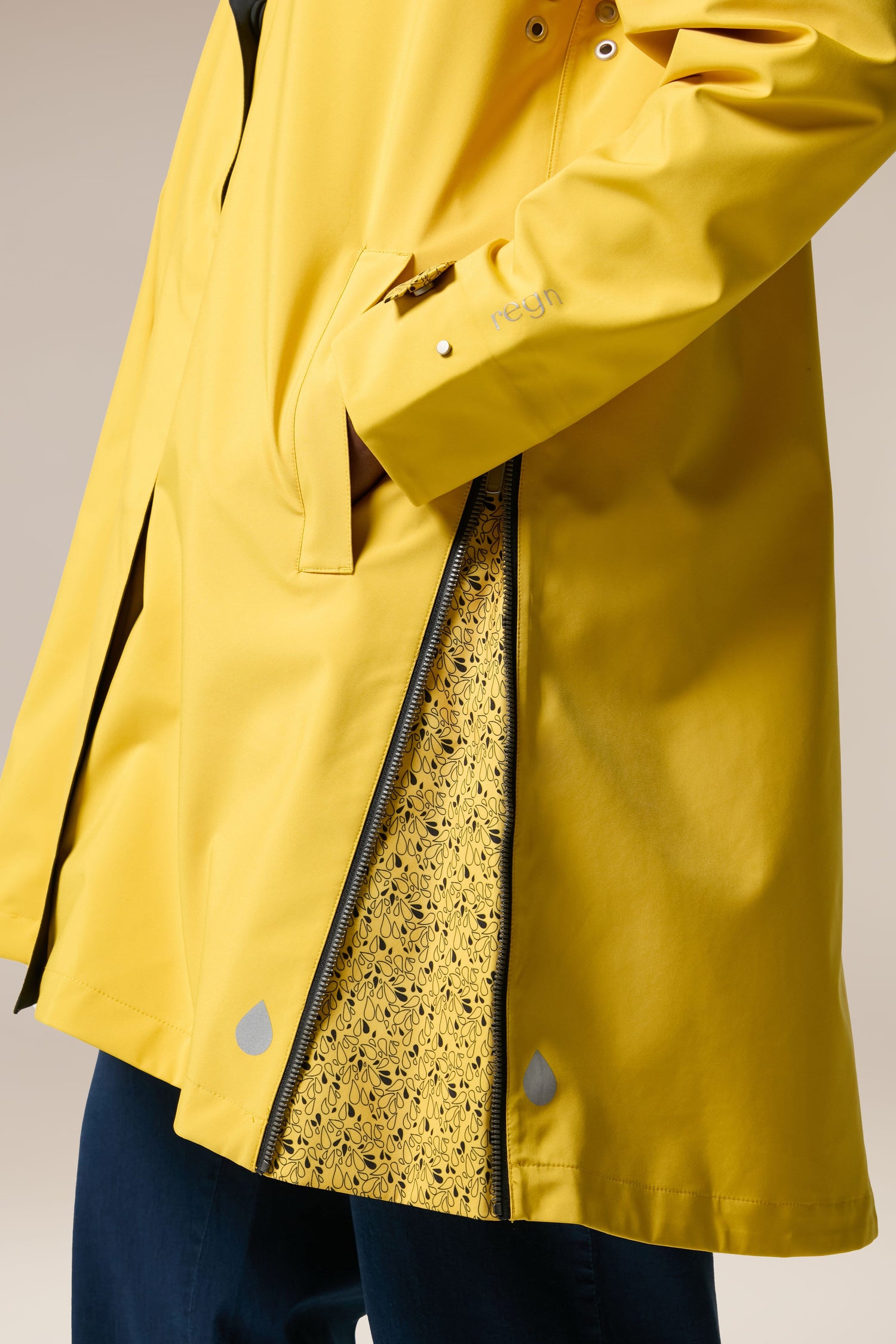 A woman is wearing the Denise Wide Collar Rain Jacket from Scandi brand Regn, made with sustainability-accredited technical fabrics.