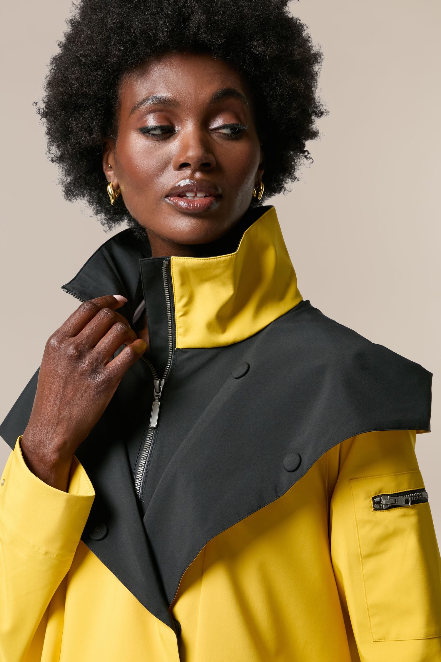 A woman wearing the Denise Wide Collar Rain Jacket from the Scandi brand Regn.